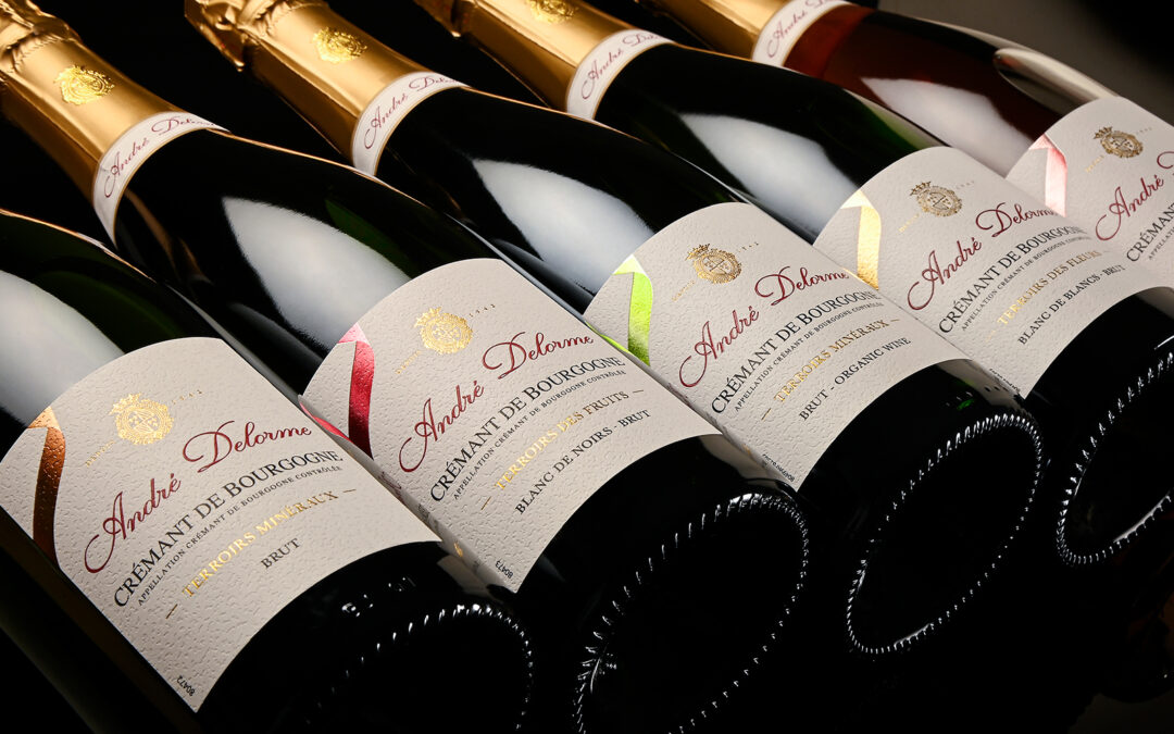 Bouteille de crémant haut de gamme André Delorme avec étiquette en papier martelé, dorure or et ruban personnalisé
